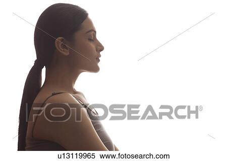 Stock Photography - Side view of young woman meditating isolated over white background. Fotosearch