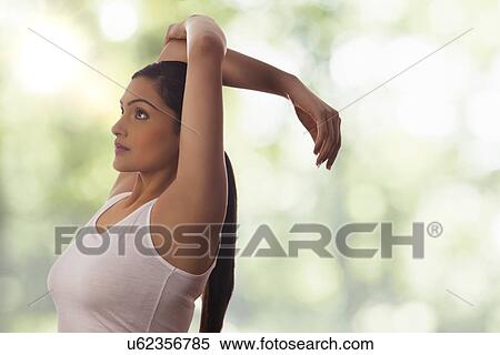 Side view of young woman stretching against glass View Large Photo Image Stock Photography - Side view of young woman stretching against glass. Fotosearch