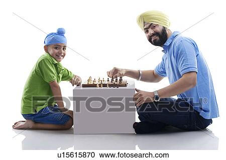 Stock Image - Sikh boy playing chess with his dad . Fotosearch