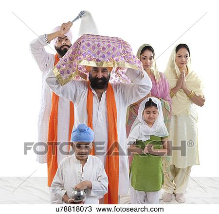 Stock Image - Sikh family performing a ritual ceremony . Fotosearch