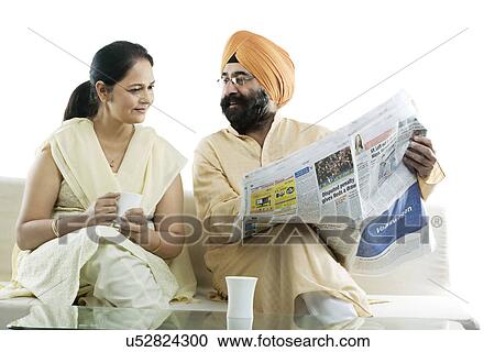 Sikh man showing an article in the newspaper to his wife View Large Photo Image Stock Image - Sikh man showing an article in the newspaper to his wife . Fotosearch