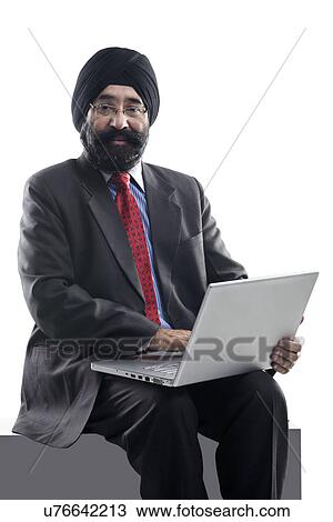 Stock Image - Sikh man with a laptop . Fotosearch