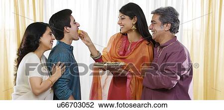 Stock Image - Sister feeding her brother during Rakhi . Fotosearch