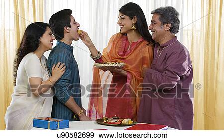 Stock Photo - Sister feeding her brother during Rakhi . Fotosearch
