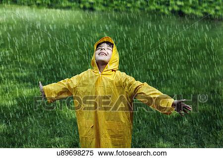 Smiling boy wearing raincoat in park View Large Photo Image Stock Photography - Smiling boy wearing raincoat in park . Fotosearch