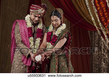 Stock Image - Smiling bride and bridegroom during traditional ceremony . Fotosearch