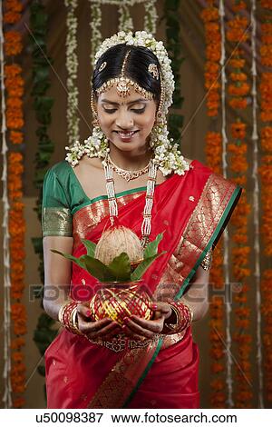 Smiling bride holding kalash View Large Photo Image Stock Photo - Smiling bride holding kalash . Fotosearch