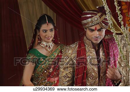 Stock Photo - Smiling bride looking at man during mangal phera . Fotosearch