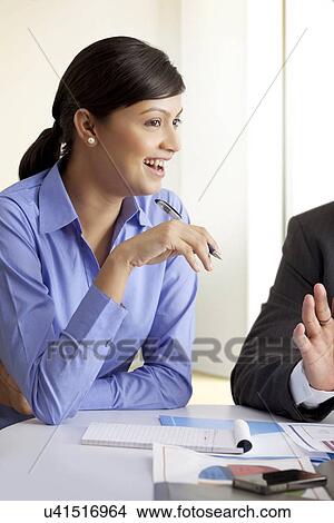 Smiling businesswoman in discussion with colleagues View Large Photo Image Picture - Smiling businesswoman in discussion with colleagues . Fotosearch