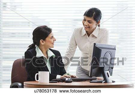 Stock Photo - Smiling female executives in discussion about business . Fotosearch
