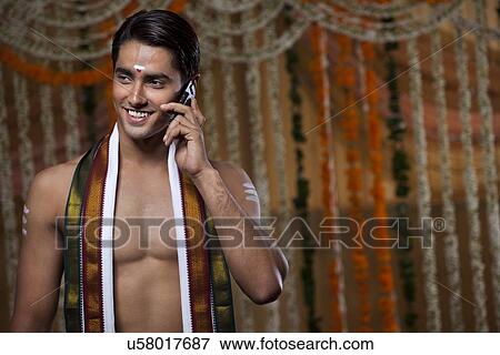 Stock Photo - Smiling groom having conversation on mobile phone . Fotosearch