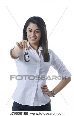 Smiling Indian businesswoman holding car keys against white background View Large Photo Image Stock Photography - Smiling Indian businesswoman holding car keys against white background. Fotosearch