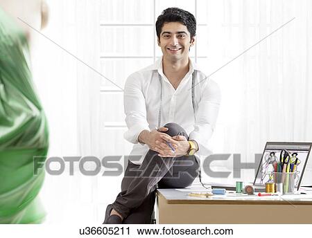 Stock Image - Smiling male clothing designer in workshop . Fotosearch