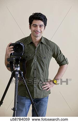 Smiling male photographer over colored background View Large Photo Image Stock Photo - Smiling male photographer over colored background . Fotosearch