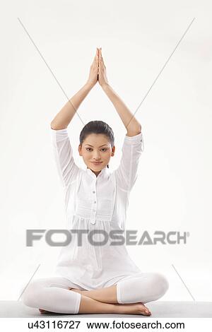 Smiling young woman doing yoga over white background View Large Photo Image Stock Photo - Smiling young woman doing yoga over white background . Fotosearch