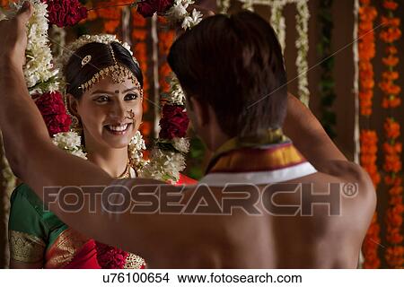 Picture - Smiling young woman looking at husband during wedding ceremony . Fotosearch