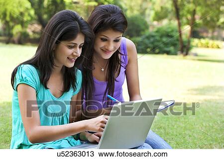Smiling young women taking notes from laptop View Large Photo Image Stock Image - Smiling young women taking notes from laptop . Fotosearch