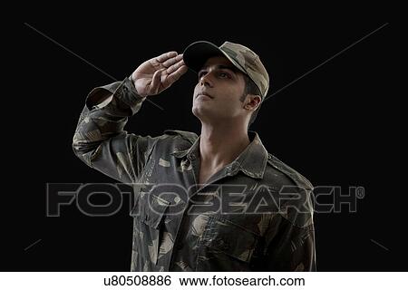 Stock Photograph - Soldier saluting while looking up against black background . Fotosearch