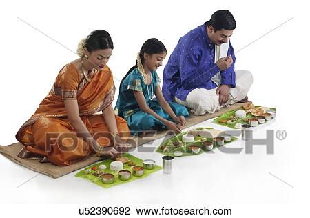 Stock Image - South Indian family having lunch . Fotosearch