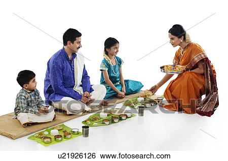 Stock Photograph - South Indian woman serving food to her family . Fotosearch