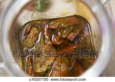 Stock Image - Stuffed red chilli pickle in a jar . Fotosearch