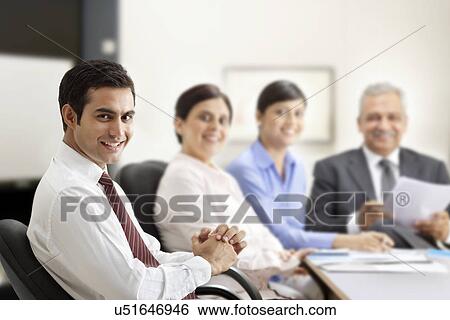 Stock Photograph - Successful businessman smiling with executives in a meeting . Fotosearch