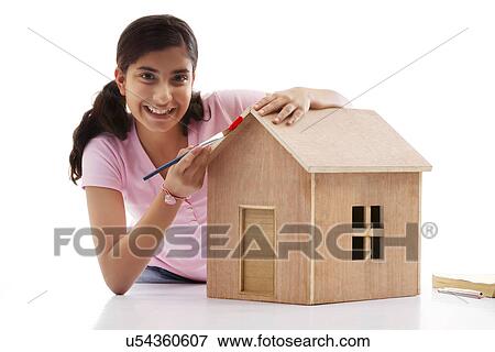 Teenage girl painting a wooden house View Large Photo Image Stock Photo - Teenage girl painting a wooden house . Fotosearch