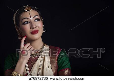 Stock Photography - Thoughtful Bharatanatyam dancer over black background. Fotosearch