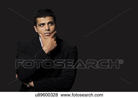 Thoughtful business man over black background View Large Photo Image Stock Photo - Thoughtful business man over black background . Fotosearch
