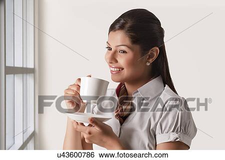 Thoughtful businesswoman having cup of tea for refreshment View Large Photo Image Stock Photograph - Thoughtful businesswoman having cup of tea for refreshment . Fotosearch