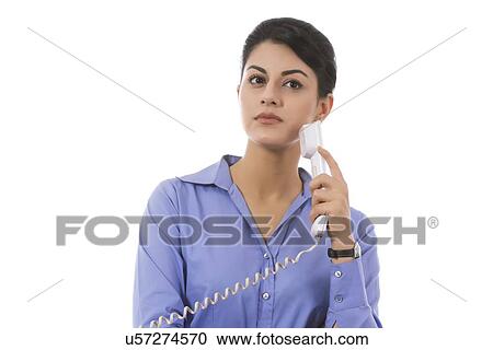 Thoughtful businesswoman holding telephone receiver over white background View Large Photo Image Stock Image - Thoughtful businesswoman holding telephone receiver over white background. Fotosearch