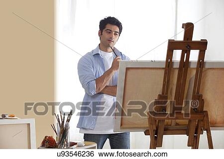 Stock Photograph - Thoughtful male painter in studio looking for inspiration . Fotosearch
