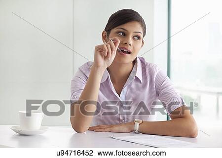 Thoughtful young female executive preparing project View Large Photo Image Stock Image - Thoughtful young female executive preparing project . Fotosearch