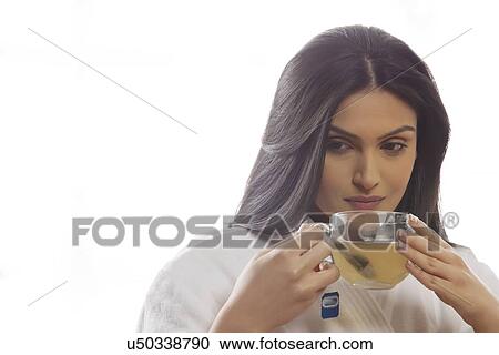 Stock Image - Thoughtful young woman holding tea cup . Fotosearch