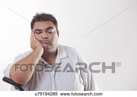 Stock Photo - Tired obese man with hand on chin over white background . Fotosearch