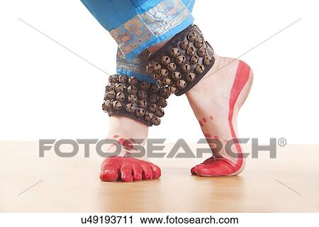 Stock Image - Traditional dancer's feet performing Bharatanatyam against white background. Fotosearch