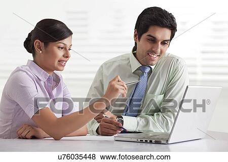 Two businesspeople preparing presentation while using laptop View Large Photo Image Stock Photo - Two businesspeople preparing presentation while using laptop . Fotosearch