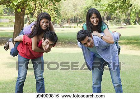 Stock Photograph - Two couples piggybacking on campus . Fotosearch