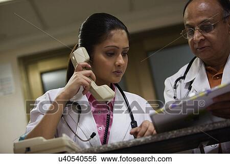 Two doctors discussing work View Large Photo Image Stock Photograph - Two doctors discussing work . Fotosearch