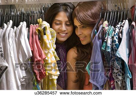 Two friends shopping for dresses together at store View Large Photo Image Stock Photo - Two friends shopping for dresses together at store . Fotosearch