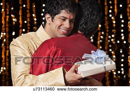 Stock Image - Two men hugging each other. Fotosearch