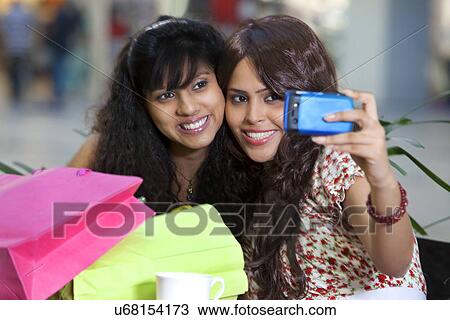Stock Image - Two young woman taking self portrait . Fotosearch