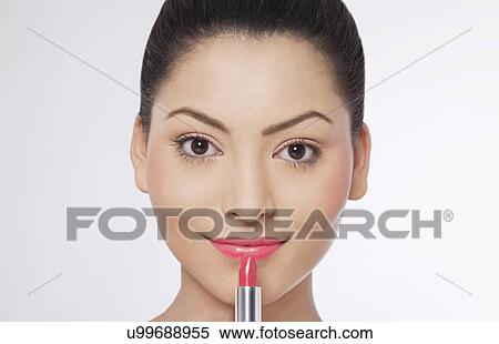 Stock Photography - Woman applying lipstick . Fotosearch