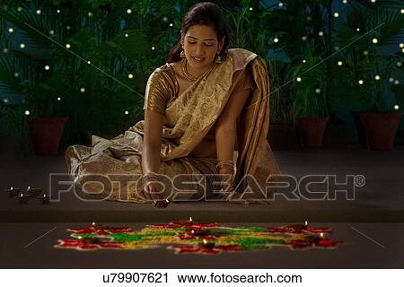 Stock Image - Woman arranging diyas . Fotosearch