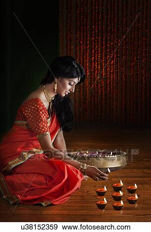 Woman arranging diyas View Large Photo Image Stock Photo - Woman arranging diyas. Fotosearch