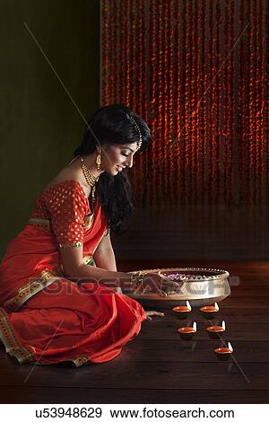 Woman arranging diyas View Large Photo Image Stock Photo - Woman arranging diyas. Fotosearch