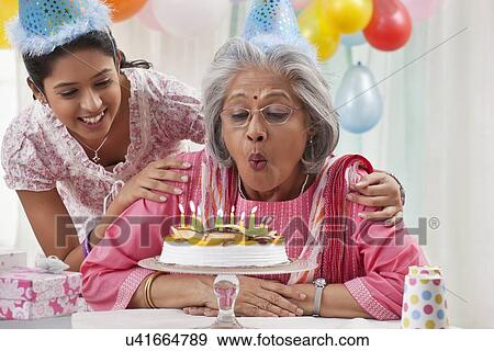 Stock Photo - Woman celebrating birthday with granddaughter. Fotosearch