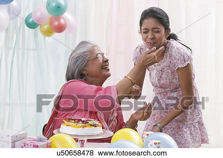 Stock Photo - Woman celebrating birthday with granddaughter. Fotosearch