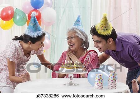 Woman celebrating birthday with grandchildren View Large Photo Image Stock Photograph - Woman celebrating birthday with grandchildren. Fotosearch