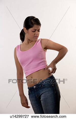 Woman checking her waist View Large Photo Image Stock Photo - Woman checking her waist . Fotosearch